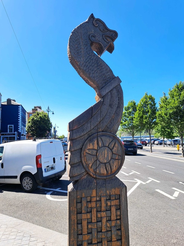 Hand-carved wooden Viking-style pillar with a Viking prow replica