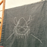 Cartoon Viking depicted on a textured dark gray, fabric