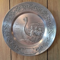 Decorative, circular pewter plate featuring a Viking longship and Norse warriors
