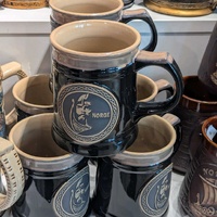 Black and beige ceramic souvenir mug with Viking motif
