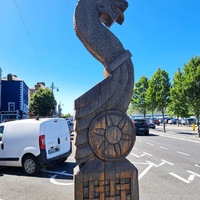 Hand-carved wooden Viking-style pillar with a Viking prow replica